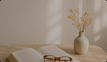 An open book with flowers in a vase on the table
